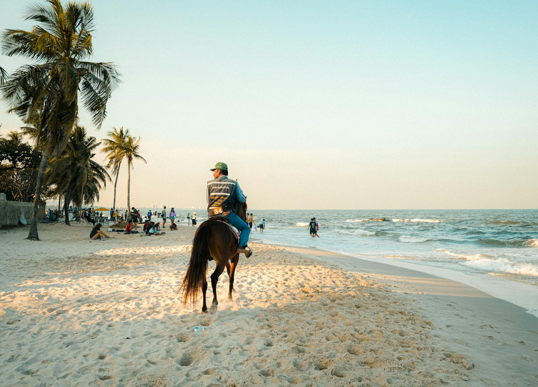 Jazda konna po słonecznej plaży w Krabi wśród palm i turystów