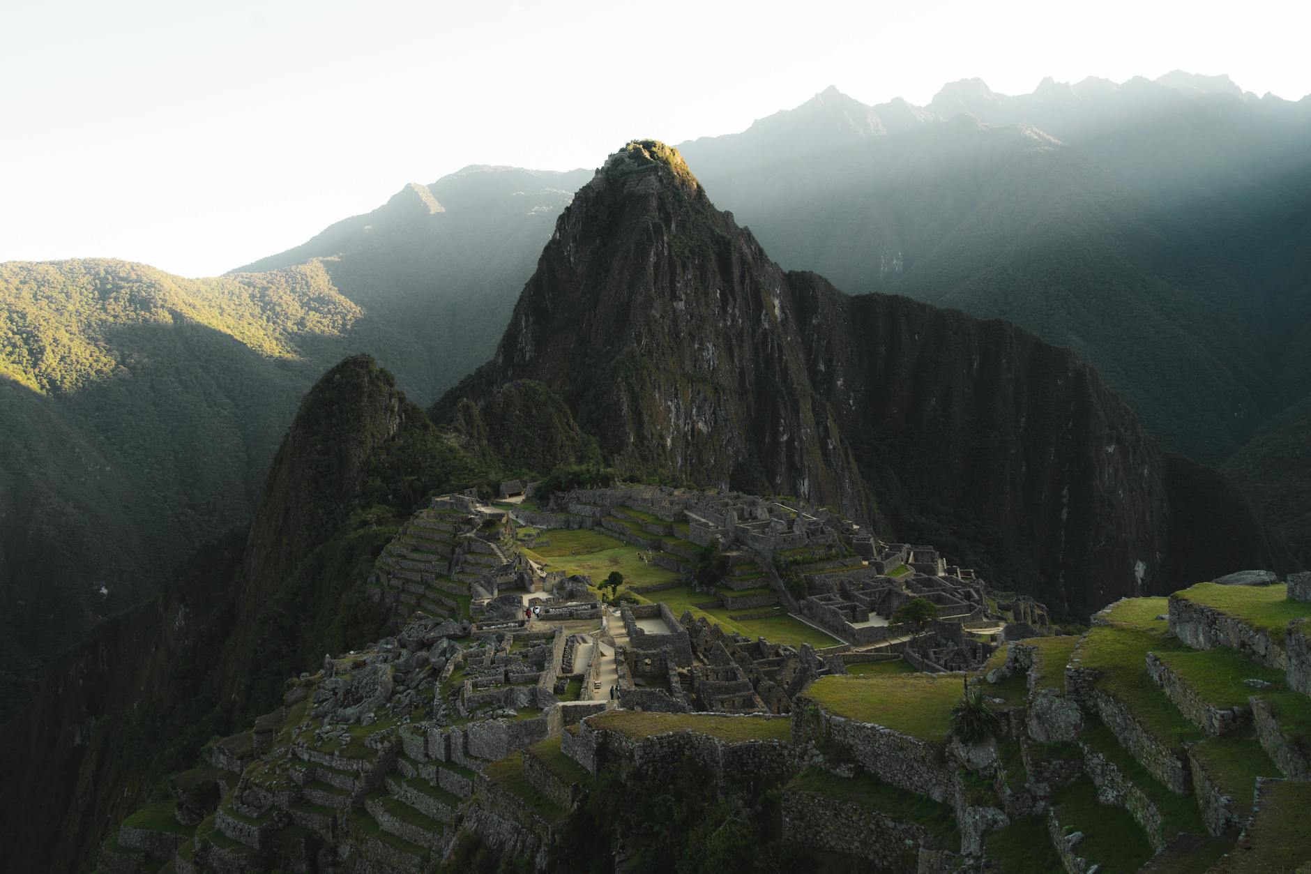 Machu Picchu bez tłumów: kiedy jechać i jak kupić bilety Machu Picchu o wschodzie słońca, ruiny nad mglistymi górami Peru