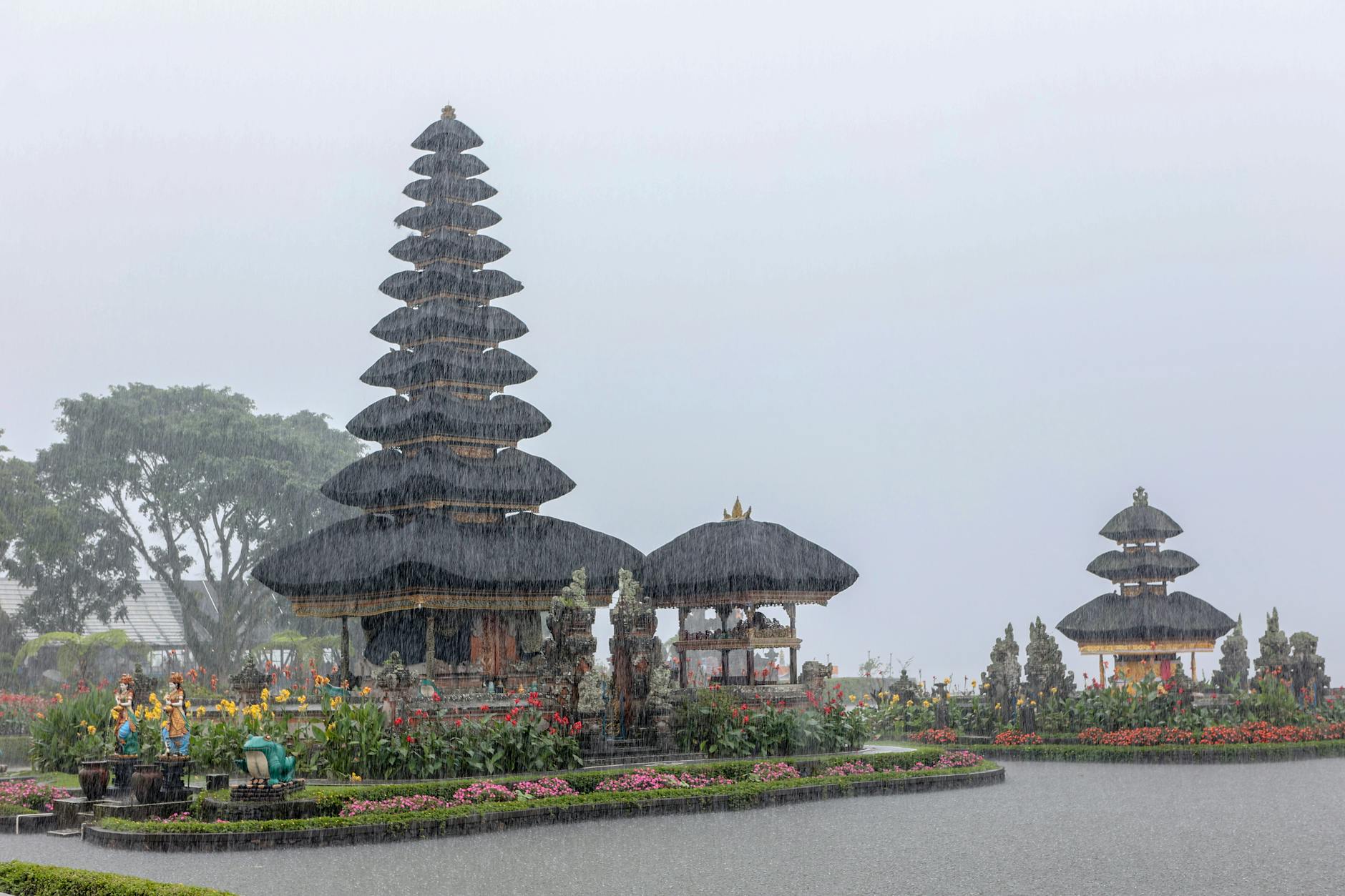 Świątynia Ulun Danu Bratan na Bali w deszczu, otoczona zielenią i kwiatami