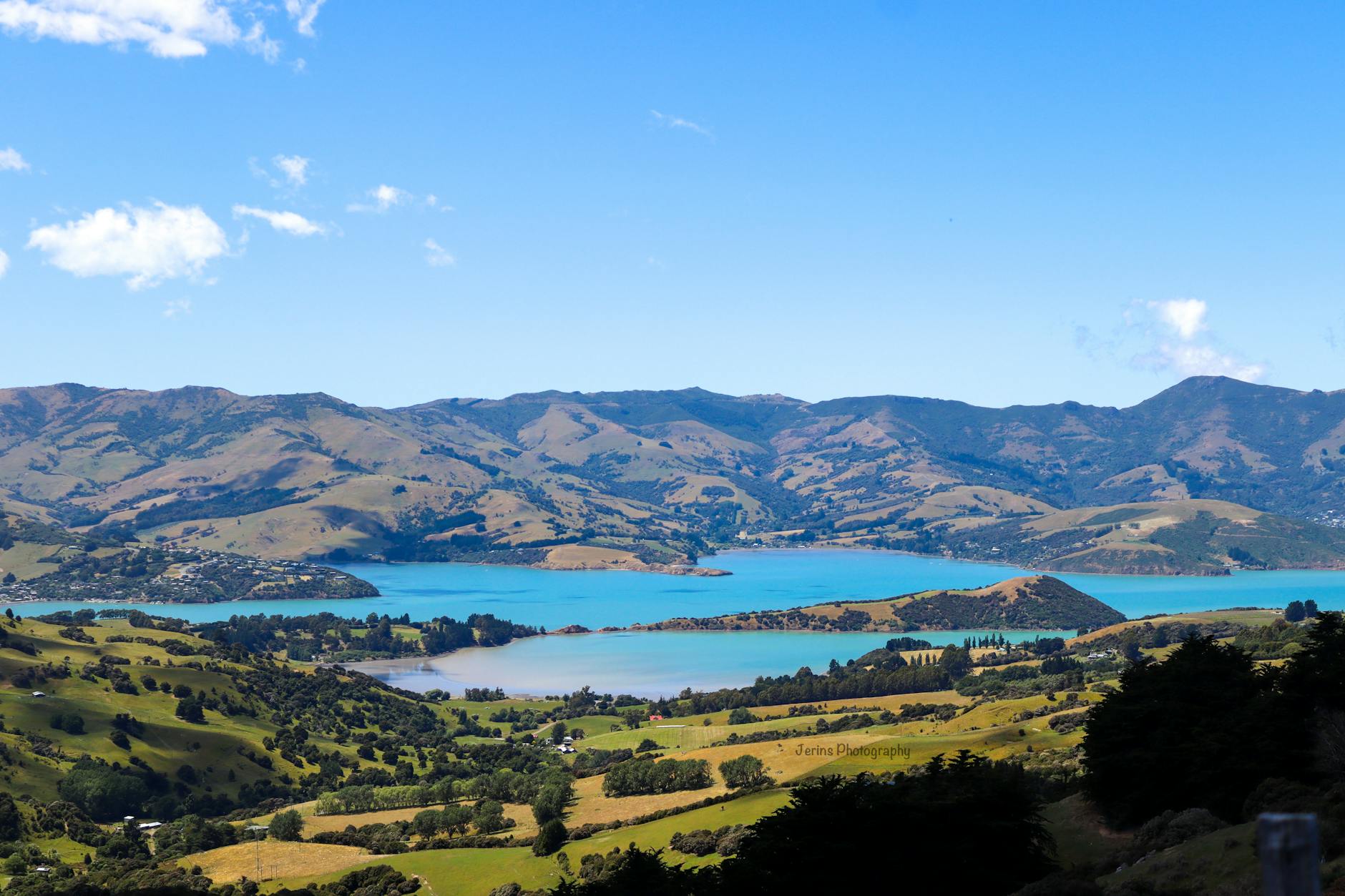 Widok z lotu ptaka na zatokę Akaroa otoczoną zielonymi wzgórzami