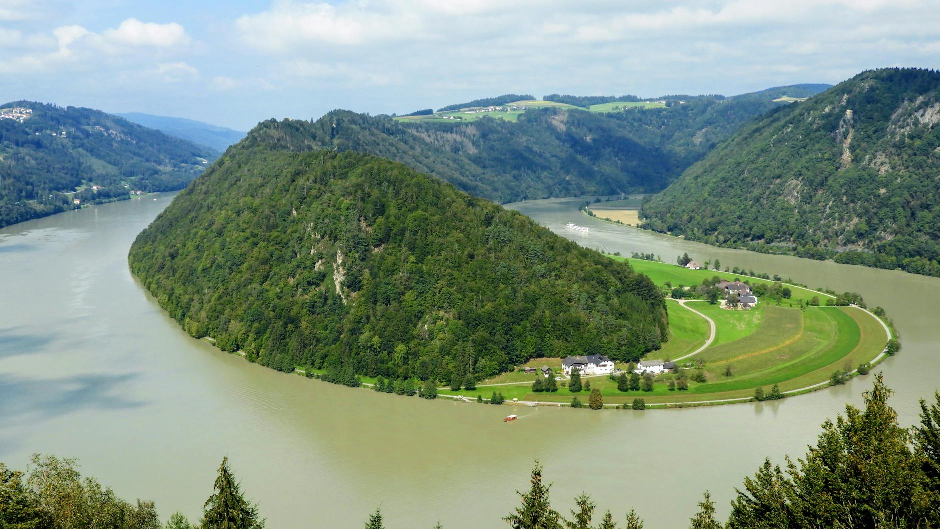 Zakole Dunaju wśród zielonych wzgórz w słoneczny dzień