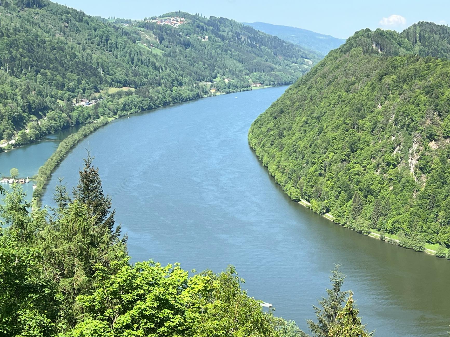 Zakole rzeki w zielonej dolinie otoczonej zalesionymi wzgórzami